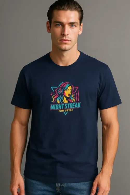 A young man wearing a navy blue graphic t-shirt featuring a vibrant design of a woman with headphones and the text "NIGHT STREAK EDM STYLE." The shirt is styled with a casual look, paired with denim jeans, and set against a neutral background that highlights the shirt's colors and design.